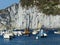 Cliff white rocks with small boats in front of to Ponza in Italy.