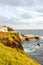 Cliffs by the Atlantic ocean in fishermans village Lagoa, Sao Miguel Island, Azores, Portugal. Traditional houses on the