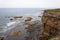 Cliffs at Barents Sea on summer foggy day