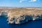 Cliffs and blue lagoons of Gozo seen from above. Aerial view of Gozo, Malta. Dome of Rotunda of Xewkija dominates the island.
