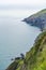 Cliffs and hillside in Wicklow, Ireland. Irish sea on left. Vertical shot with mist in background.