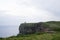 Cliffs at Moher on a rainy day. Green fields and ancient tower