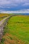 Cliffs of Moher seaside path stone wall and pasture lands overlooking Liscanor Bay