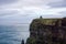 Cliffs of Moher in Wild Atlantic Way with ruins of tower on edge of cliff