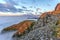 Cliffs of Northern cape of Soroya Island in midnight sun light. Fascinating sea of clouds is covering the Arctic Ocean surface at