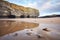 cliffs reflecting on wet sand at low tide