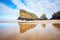 cliffs reflecting on wet sand at low tide