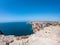 Cliffs on west coast of Atlantic Ocean in Sagres, Algarve, Portugal. Horizon over water against claer blue sky