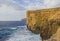 Cliffs where Azure Window collapsed lit by sunset light at the coast of Island Gozo.