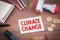 Climate Change. Wooden office desk with stationery, money and a note pad
