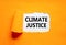 Climate justice symbol. Concept words Climate justice on beautiful white paper. Beautiful orange paper background. Business