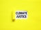 Climate justice symbol. Concept words Climate justice on beautiful white paper. Beautiful yellow paper background. Business