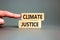 Climate justice symbol. Concept words Climate justice on beautiful wooden blocks. Beautiful grey table grey background.