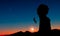 A climber abseiling down from a rocky peak at sunset