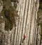 Climber ascending difficult stone wall