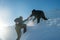 Climber assists another climber on the slope of snowy mountains