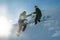 Climber assists another climber on the slope of snowy mountains