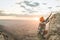 Climber climbing a rock in the mountain at sunset. Hiker climbing a rock