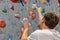 Climber explores and develops a route on a climbing wall in the boulder hall