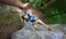 Climber hanging on rope between rocks and stretching out his hand. Hand helping in the rock climbing.