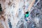 Climber holding on handhold while climbing cliff