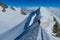 Climber on a knife edge snow mountain ridge