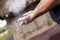 Climber man coating her hands in powder chalk magnesium.