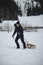 Climber pulls to top of wooden sled for ride on the piste. Going back to childhood. Candid portrait of a man pulling a sledge,