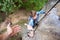 Climber rock climbing overhanging cliff with rope. Asking for help. Man helping his friend to climb a rock.