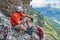 Climber taking a break on via ferrata dei Finanzieri, in Dolomites mountains, above Alba di Penia, Italy, during Summer