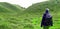 A climber walks along the green and beautiful savanna on Mount Prau