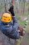 Climber walks on logs holding safety rope