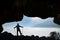 Climber watching foggy landscape from cave