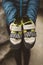 Climber woman with her climbing shoes placed on her hands.