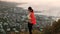 climber woman standing on the mountain looking at the horizon in a red jacket