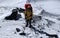 Climber in a yellow jacket with an ice ax goes to the top of the volcano along a snow-covered trail