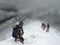 Climbers entering a dark abyss during winter blizzard in the mountain