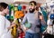 Climbers examining alpinism equipment items in sports shop