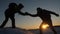 Climbers help friend climb stretch of helping hand. two tourists at top of mountain. Silhouette of travelers in winter