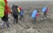 Climbers with large backpacks and trekking poles walk along the lava fields of Kamchatka