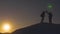 Climbers raised their hands up and jumping from happiness after conquering a high snowy mountain in glare of sunset