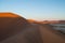 Climbing Big Daddy Dune during Sunrise with View onto Salt Pan