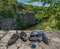 Climbing gear equipment on rock on river canyon background. Climb shoes, belaying carabiners, loops, ropes, bag for magnesia,