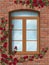 Climbing rose arched window in brick wall