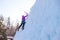 Climbing up vertical ice waterfall