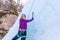 Climbing up vertical ice waterfall