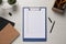 Clipboard with checkboxes, plant and office stationery on white wooden table, flat lay. Checklist