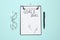 Clipboard with inscription Goals 2021, new year aims. Objects on turquoise background, flat lay