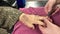 Clipping cutting fingernail of senior woman by young caregiver with clippers. Onychomycosis or tinea unguium, common in elderly,