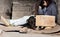 Clochard sitting with his dog on backstreet yard